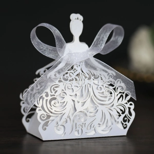Detail of laser-cut white favor box with elegant princess gown silhouette and silk bow