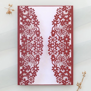 Detailed laser-cut burgundy invitation cover with butterfly and floral patterns