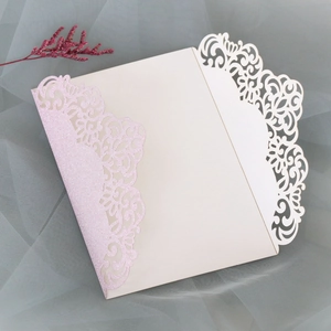 Détail macro d'une invitation découpée au laser avec dentelle florale pailletée et carton ivoire