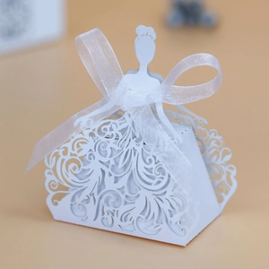Close-up of white laser-cut wedding favor box with princess silhouette and ribbon