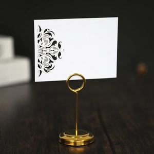 Close-up of golden metal card holder with elegant laser-cut lace pattern place card