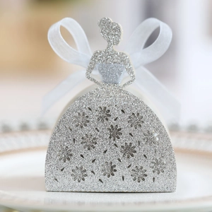 Gros plan d'une boîte à bonbons argentée pailletée en forme de robe avec fleurs évidées