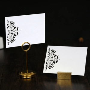 Laser-cut white table card with elegant mandala pattern and gold metal card holder stand