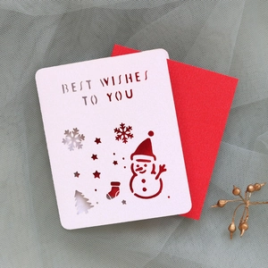 Detail of laser-cut Christmas card with snowman motifs and red inner sheet on mesh fabric
