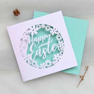 Détail de carte Happy Easter découpée au laser avec enveloppe vert menthe sur fond décoratif