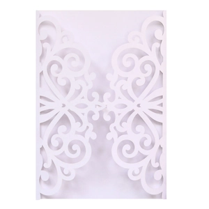 Macro detail of laser-cut white wedding invitation shell with intricate floral pattern