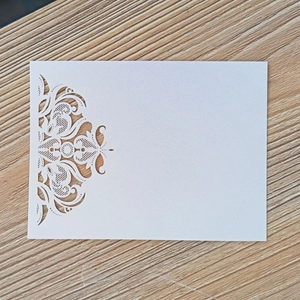 Detailed macro view of laser-cut lace pattern on elegant pearl white paper card