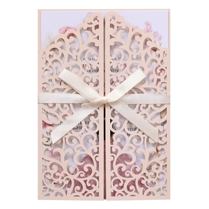 Detailed laser-cut floral pattern with ivory silk bow on light pink wedding invitation