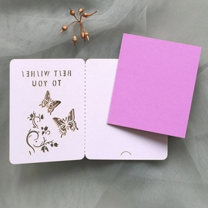 Detail of laser-cut butterfly and floral patterns with Best Wishes text on a gift card