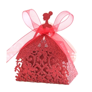 Détail de la boîte à bonbons de mariage pailletée rouge en forme de robe avec ruban