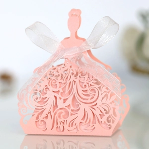 Detail of pink laser-cut princess dress candy box with white ribbon and floral patterns