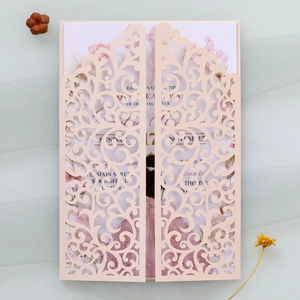 Detail of pink laser-cut wedding invitation with elegant floral illustration inside