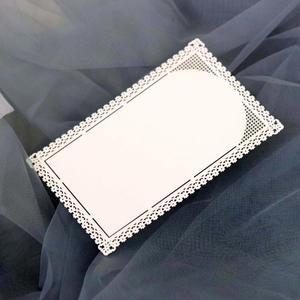Detailed macro view of white laser-cut lace card with delicate floral hollow patterns