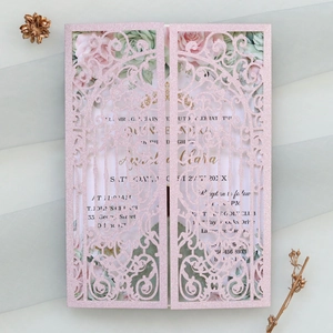 Detail view of laser-cut glitter pink wedding invitation with floral printed inner card