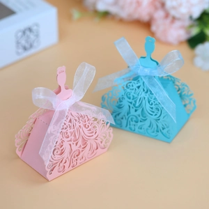 Detail of laser-cut princess dress candy boxes with intricate patterns and organza ribbons