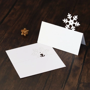 Macro shot of white snowflake laser-cut place card on rustic wood background