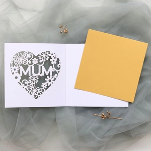 Detail of laser-cut MUM greeting card with floral heart pattern and yellow insert