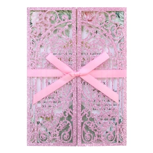 Detailed laser cut pink glitter invitation card with silk ribbon bow and floral insert