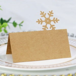 Detailed close-up of brown kraft paper place card with hollow snowflake design on a plate