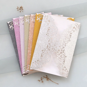 Détails de motifs floraux découpés au laser sur couvertures d'invitation dorées pailletées