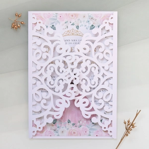 Detail of laser-cut invitation with floral inner card and elegant gold crown emblem