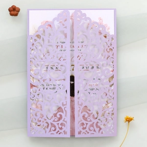 Detail of laser-cut lavender invitation featuring intricate hollow patterns and floral insert