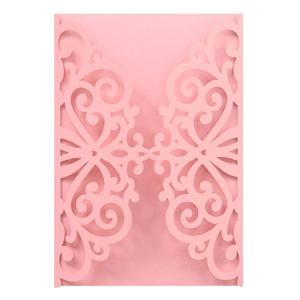 Close-up of pink laser-cut wedding invitation cover with intricate scrollwork patterns