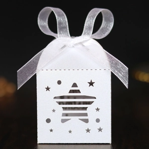 Detail of white star-shaped laser-cut gift box with elegant white ribbon and bow