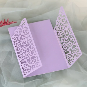 Detail of laser-cut lavender invitation card with intricate floral vine patterns