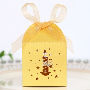 Detail of golden laser-cut Christmas candy box with star patterns and sheer ribbon