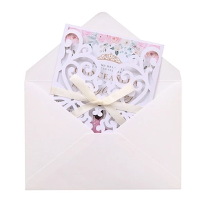 Detail of laser-cut invitation with satin bow and floral Quinceañera insert card