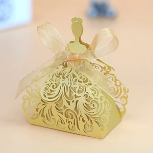 Detail of laser-cut gold princess dress candy box with elegant ribbon and bow decoration