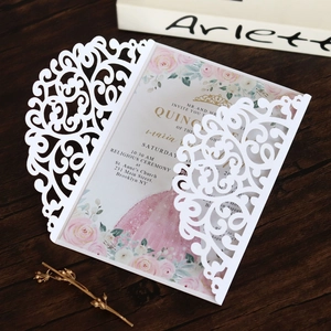 Detail of white laser-cut wedding invitation with elegant floral insert and bow