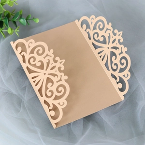 Detail of laser-cut floral patterns on kraft paper wedding invitation with mesh background