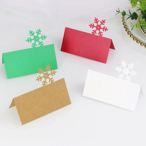 Laser cut snowflake place cards in red, green, white and kraft paper for festive tables