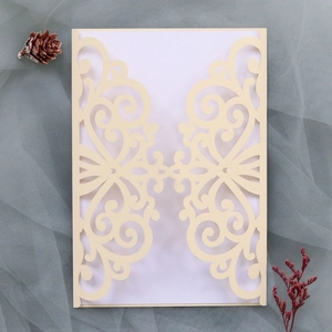 Intricate laser-cut floral wedding invitation cover on elegant grey mesh fabric background