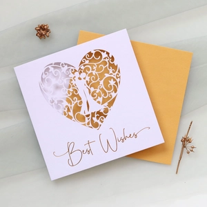 Detail of laser-cut heart greeting card with Best Wishes text and gold envelope