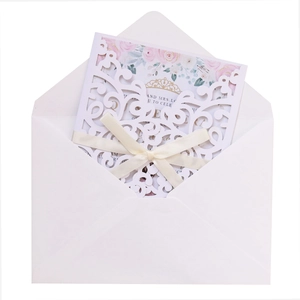Laser cut lace wedding invitation set with white envelopes and elegant silk bow detail