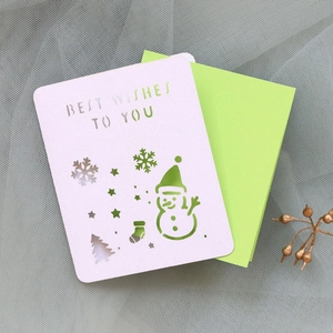 Detailed laser cut Christmas card featuring snowman and snowflake patterns with green inlay