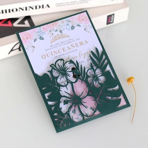 Détail de l'invitation vert foncé découpée au laser avec fleurs et accents dorés
