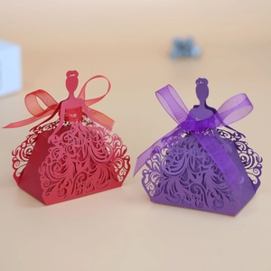 Detail view of laser-cut princess dress candy boxes with intricate patterns and ribbons