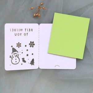 Detail of laser-cut Christmas card with snowman motifs and green inner paper insert