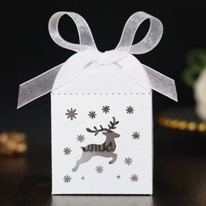 Detailed laser-cut elk and snowflake pattern on festive white favor gift box with ribbon