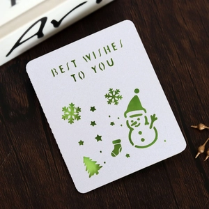 Laser-cut Christmas snowman greeting card with Best Wishes text on dark wood background