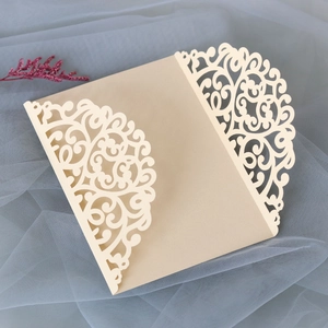 Detail of laser cut wedding invitation with intricate floral lace and cream cardstock