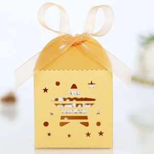 Detail of gold star cutout gift box featuring glossy pearlescent paper and ribbon