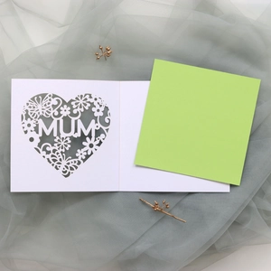 Detail of laser-cut heart card with MUM text on green insert over gray fabric