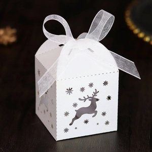 Macro detail of laser-cut reindeer and snowflake patterns on a white Christmas candy box