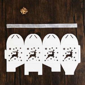 Flat lay of laser-cut reindeer Christmas candy box with elegant silver ribbon
