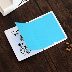 Detail of laser-cut butterfly greeting card with blue insert on a wooden surface